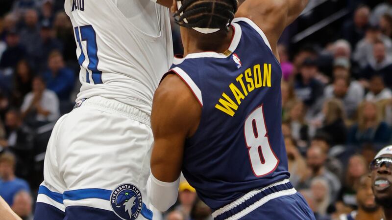 Minnesota Timberwolves center Naz Reid, left, shoots over Denver Nuggets forward Peyton Watson...