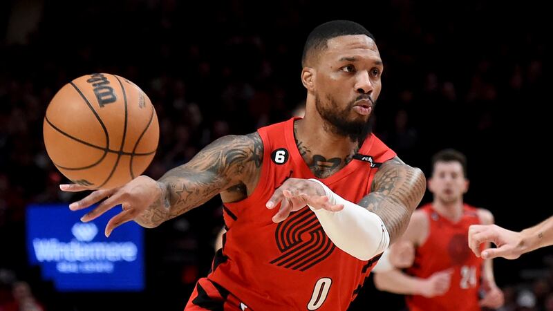 FILE - Portland Trail Blazers guard Damian Lillard, left, passes the ball against the...