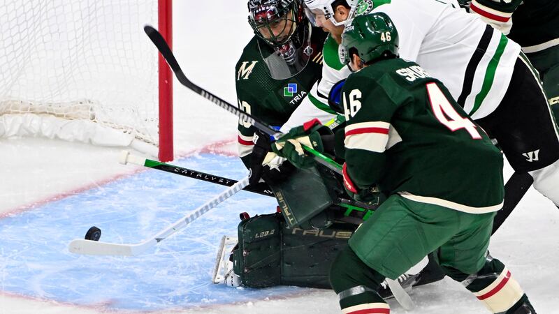 Dallas Stars center Joe Pavelski, center, scores a goal past Minnesota Wild goalie Marc-Andre...