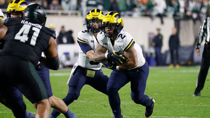 Michigan running back Blake Corum (2) takes a handoff from quarterback J.J. McCarthy during an...