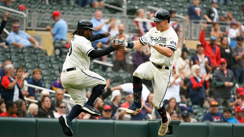 Max Kepler, derecha, de los Mellizos de Minnesota, celebra con el coach de tercera base Tommy...